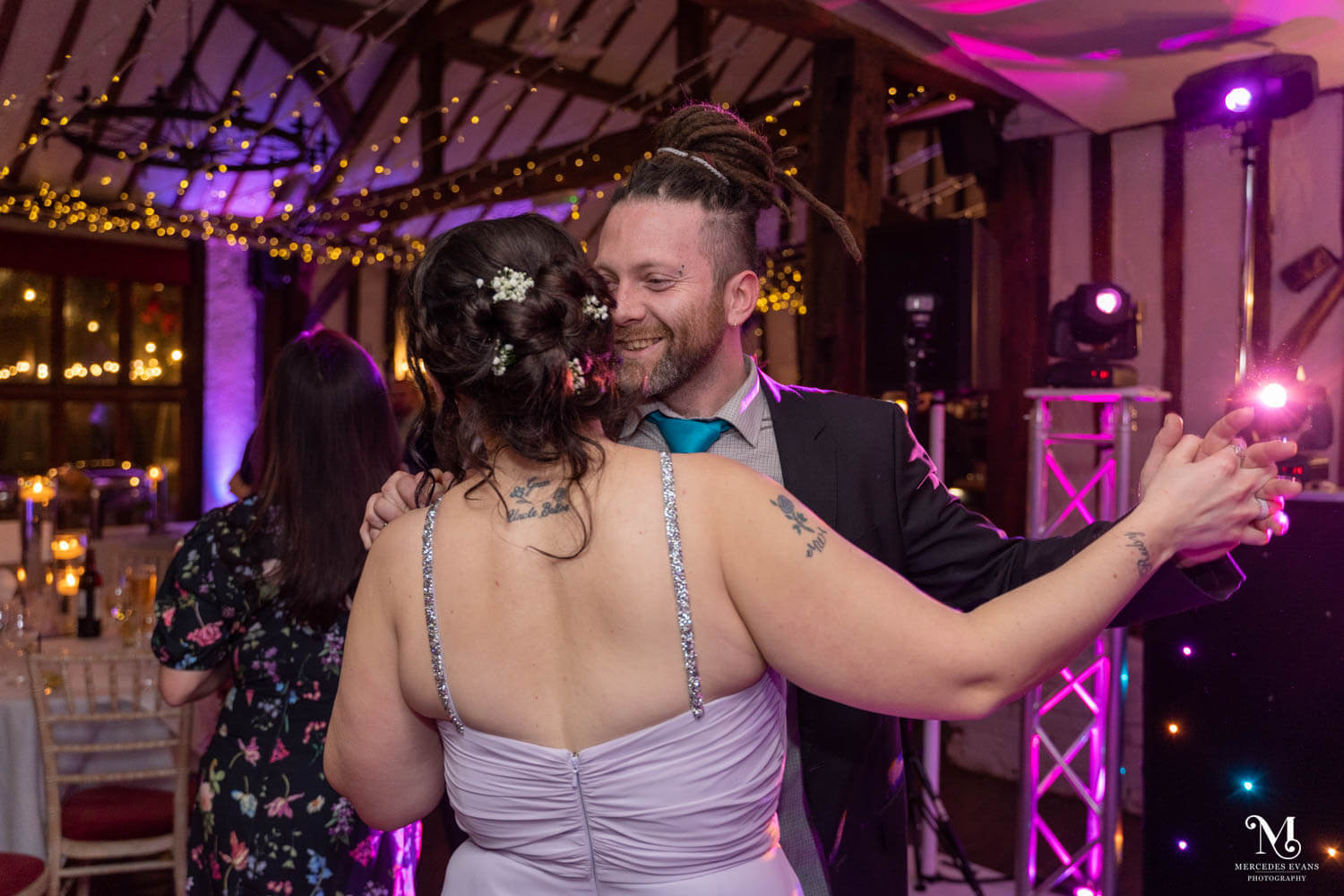 a bridesmaid and partner dance together in the evening
