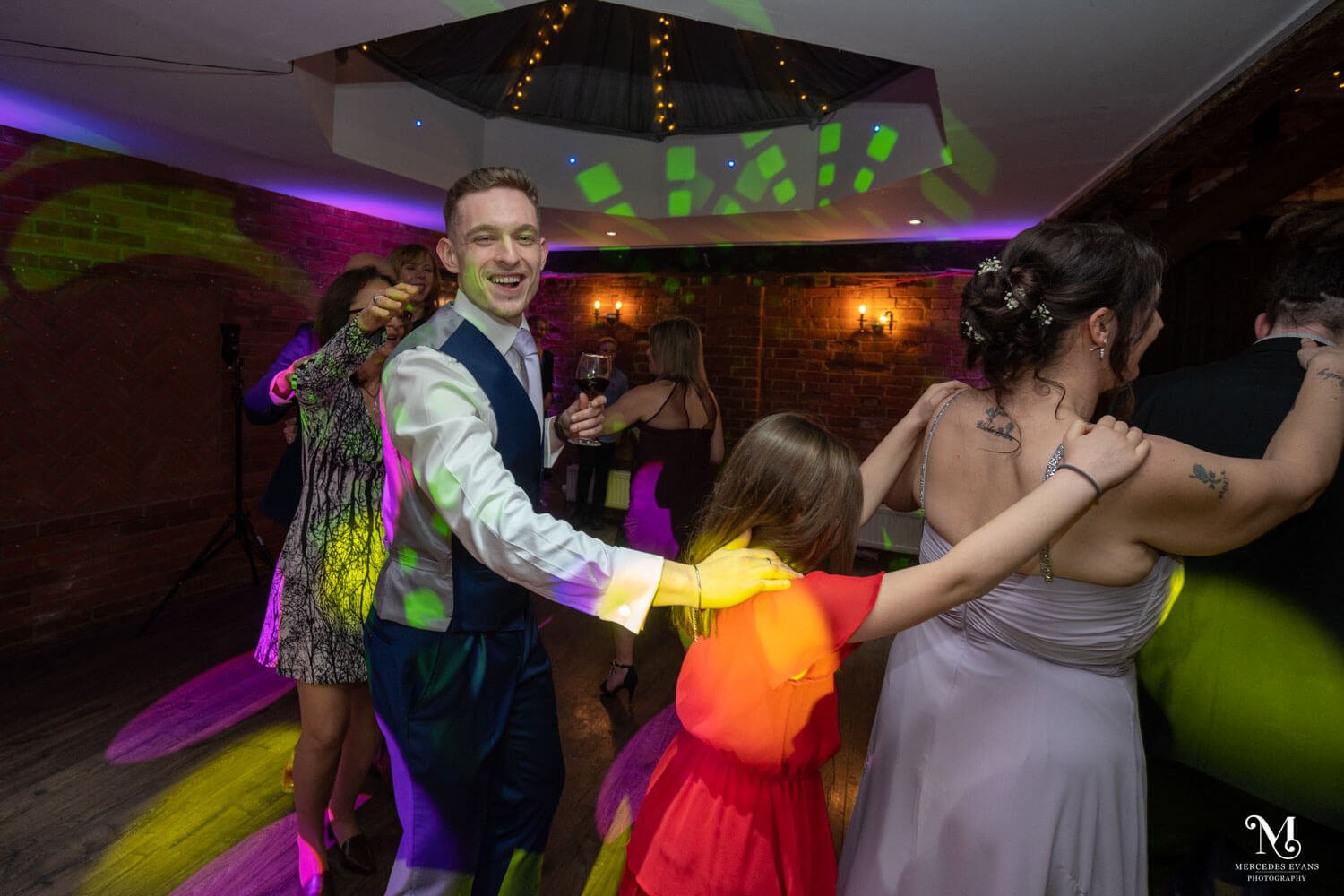 wedding guests do the conga on the evening dance floor