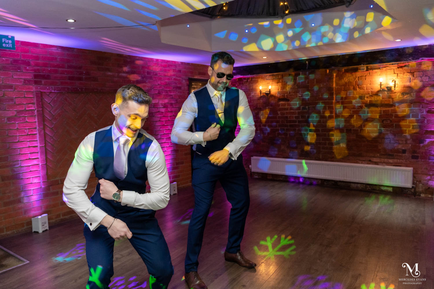 the groom and groomsmen do a dance routine on the dance floor with coloured lights