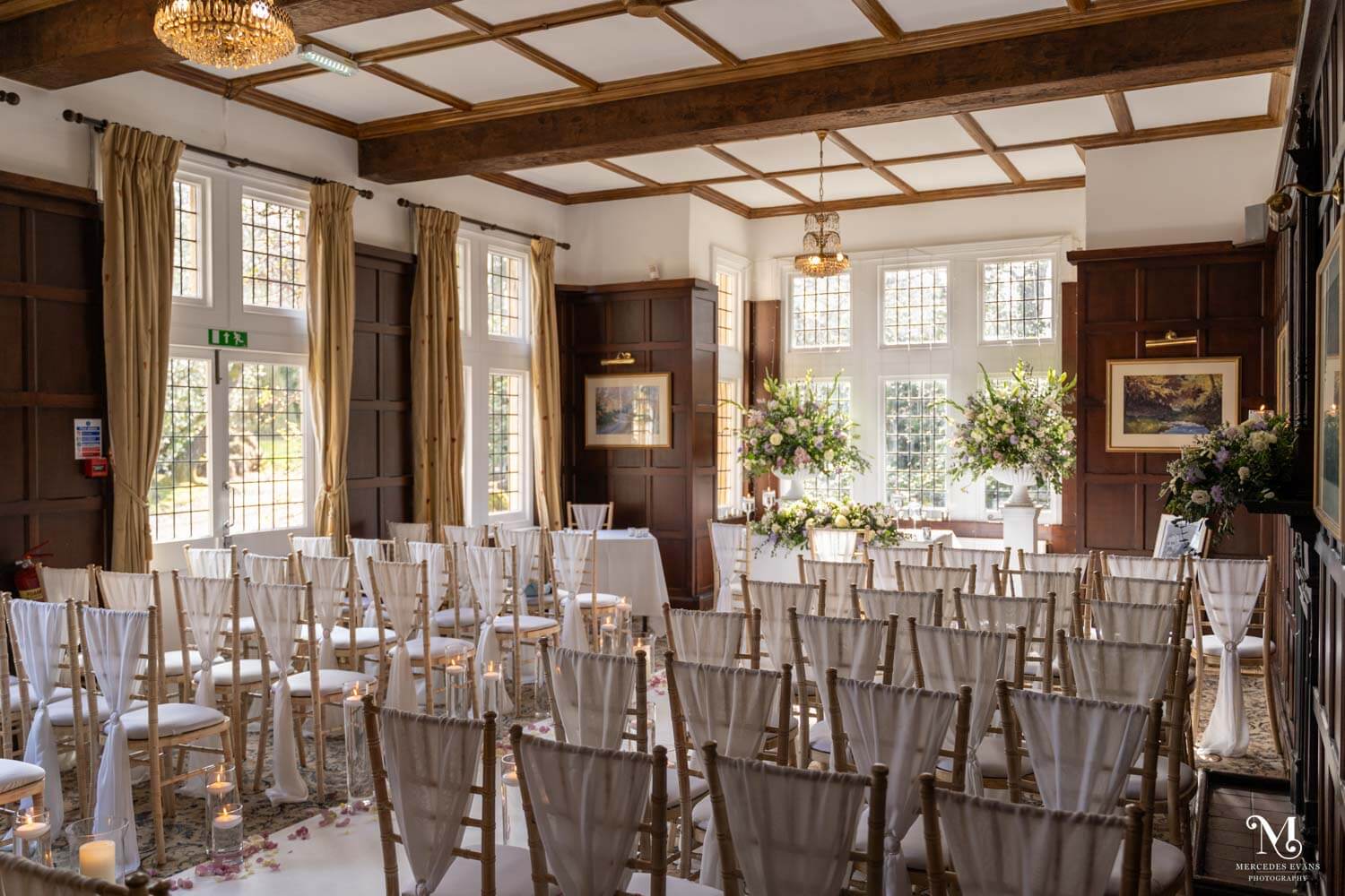 the Oak Room at cantley house set up for a wedding ceremony with huge flower pedestals and chiavari chairs