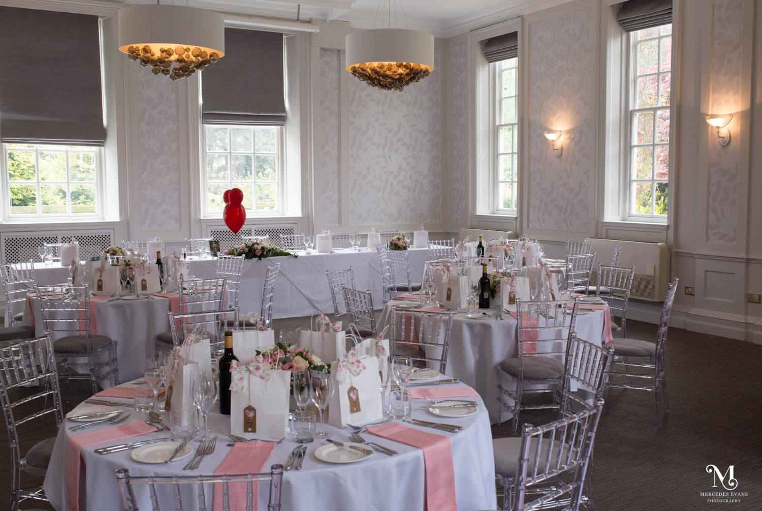 the garden suite at barnett hill hotel set up for a wedding breakfast with a pink and white theme