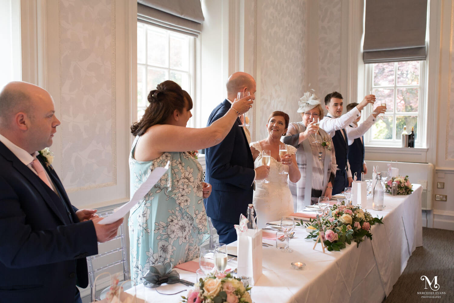 the top table toasts the happy couple with champagne