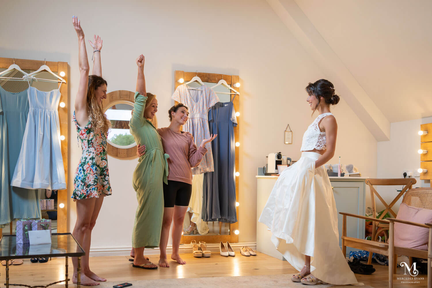 the bride shows off the pockets in her wedding skirt to her best girl friends