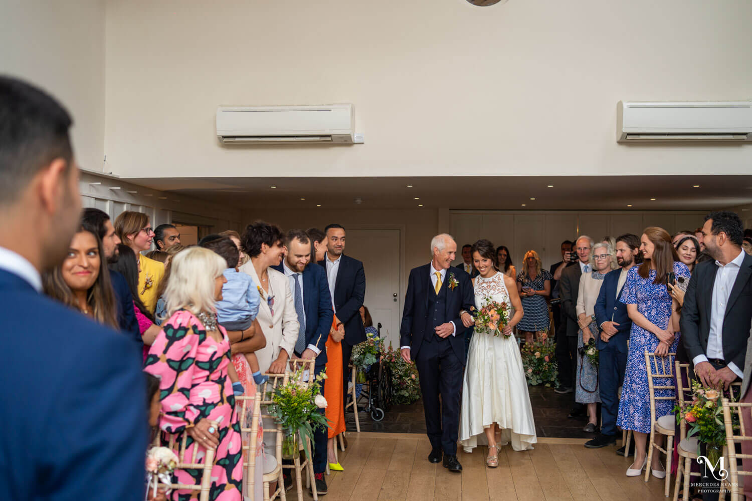 bride walks down the aisle with her father  in the hall at millbridge court