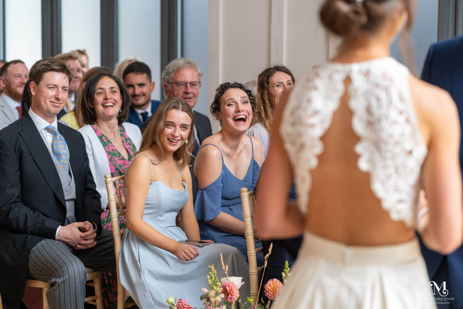 laughing guests watch during the wedding ceremony