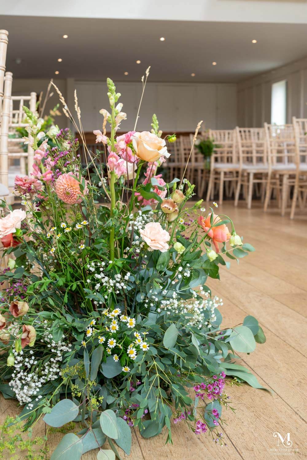 summer flower arrangement of apricot and pink flowers at the wedding venue