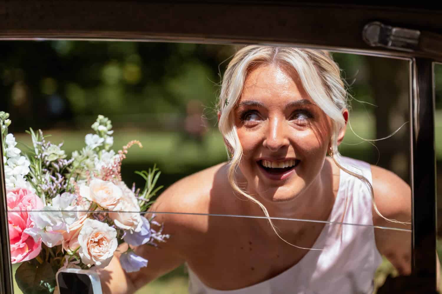 laughing bridesmaid looks up at green beetle in her hair