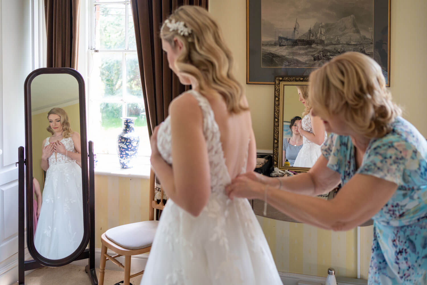 the mother of the bride does up the bride's buttons