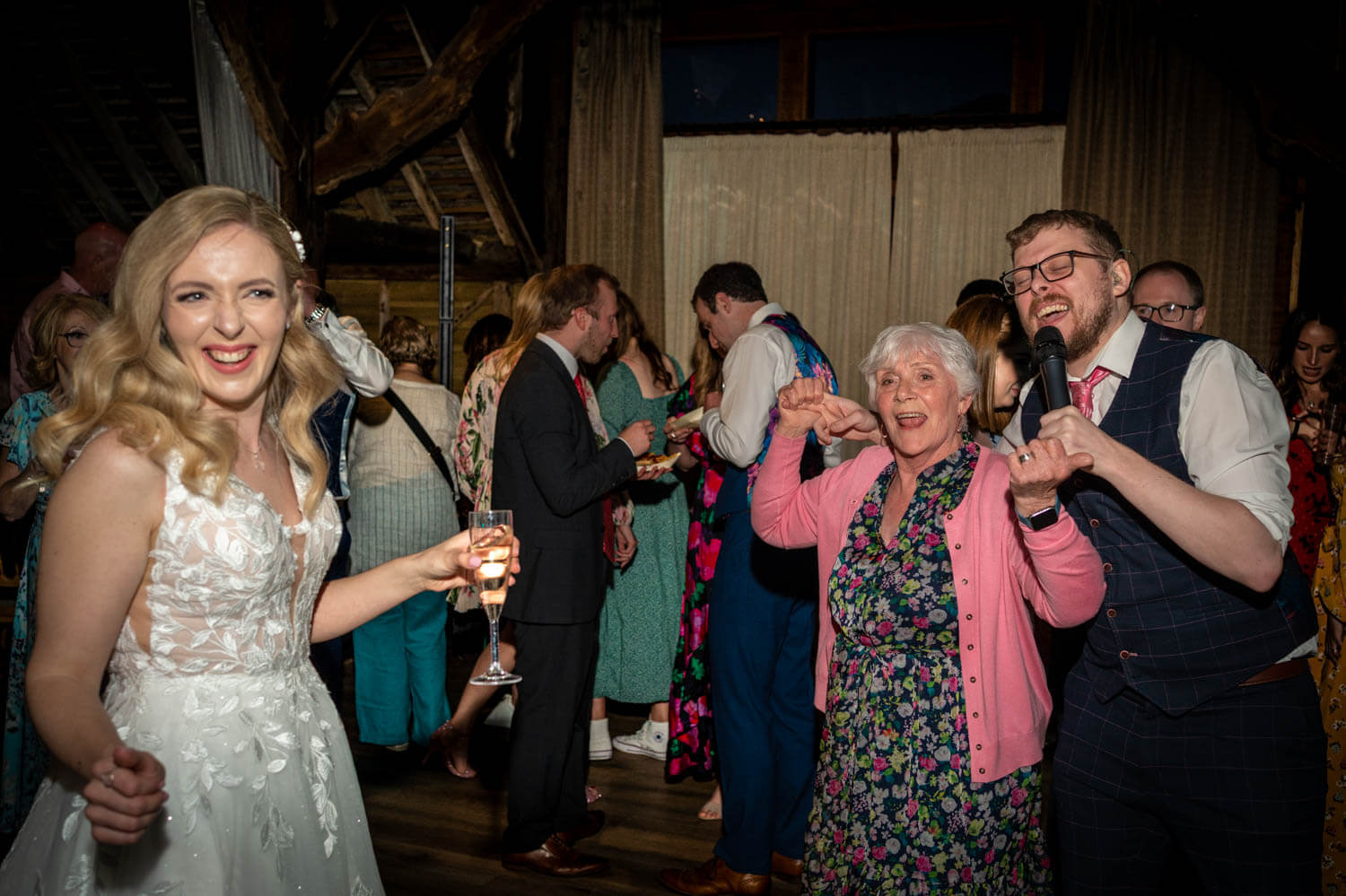 laughing bride and people on the dance floor with singer