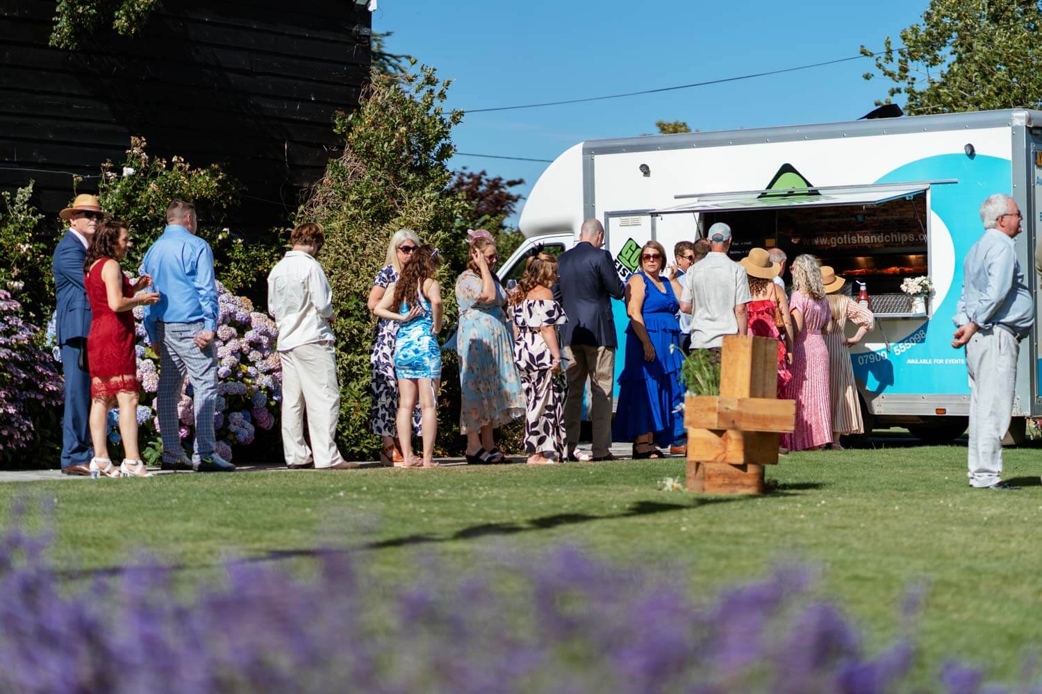 Wedding guests queuing at a food truck on the lawn during the reception at Stokes Farm Barn.